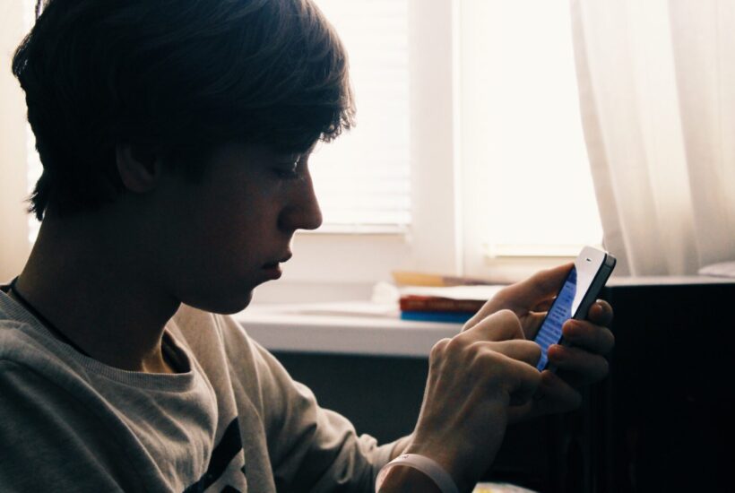 Un adolescente usando el móvil &bull; “El móvil es una droga y un posible instrumento de delito”, Emilio Calatayud